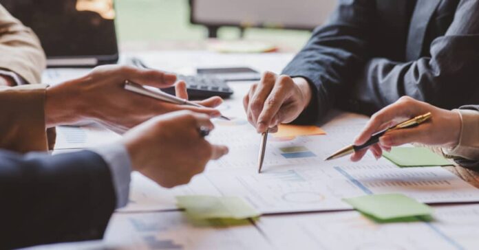 Financial analysts analyze business financial reports on digital